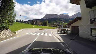 Driver point of view on scenic routes of the Dolomites from Gardena mountain pass to the village of La Villa