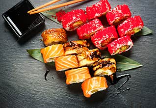 Sushi rolls closeup. Japanese food in restaurant. Roll with salmon, eel, vegetables and flying fish caviar