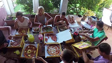 Sardinia, Italy - 22/07/2017: Family sitting at table eating pizza