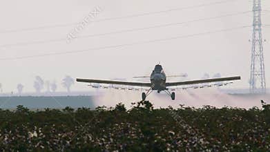 Crop duster spraying chemicals over a cotton field - slow motion