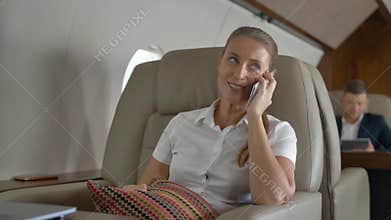 Sweet female speaking about luxury journey inside of private jet