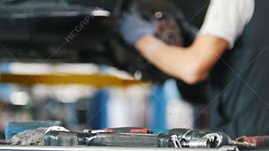 The mechanic puts the tools on the table in the car repair shop