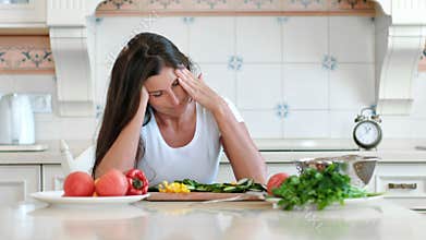 Portrait tired female housewife having headache touching head making circular massage while cooking