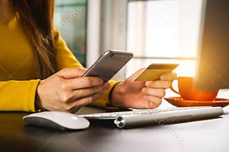 Hand olding mobile phone with credit card online banking