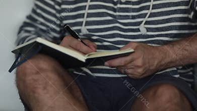 Young Hipster Male Writing Notes In His Journal In Slo-Motion