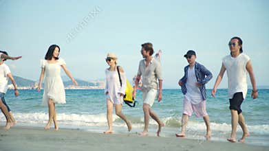 Young asian adults having fun walking on beach