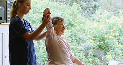 Physiotherapist giving shoulder therapy to senior woman 4k