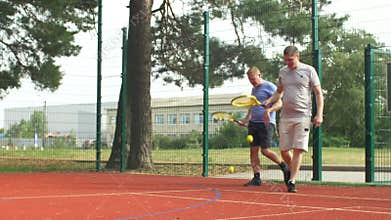 Chatting active sporty men going to tennis court