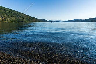 Cultus lake against the beautiful big mountain covered with coniferous forest summer landscape