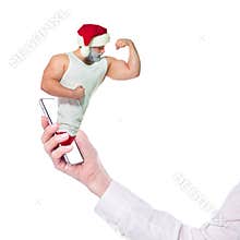 Christmas online fitness. Collage with muscular Santa Claus and smartphone in hand. The athlete shows the biceps of the