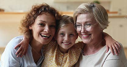 Adorable little child girl embracing mother and older granny.
