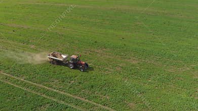 Tractor spreads mineral fertilizers on a field of farmland