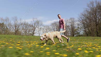 Cheerful young man with his dog in nature