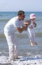 Man lifting his daughter and playing in the sea