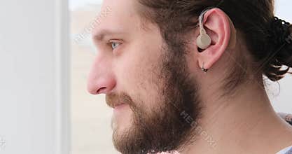 Man in hearing aid listening and shaking head
