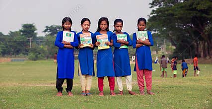 A group of school going children happy to receive their free books for rural education. Girls standing with textbooks