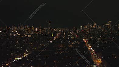 Forwards fly above metropolis at night. Multistorey apartment houses in urban borough ad high rise buildings in