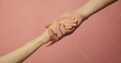 Helping hand - support, assistance and charity concept. hands reaching together on pink background