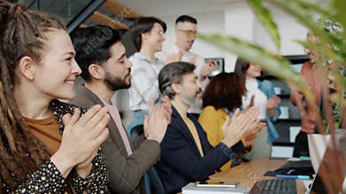 Slow motion of happy employees clapping hands and smiling celebrating business success
