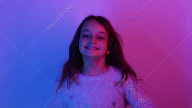 amused child joyful girl jumping in neon light