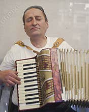 Portrait of a homeless man playing his accordion with great passion