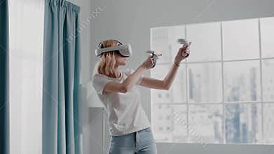 Woman shoots bow playing videogame with VR headset in room