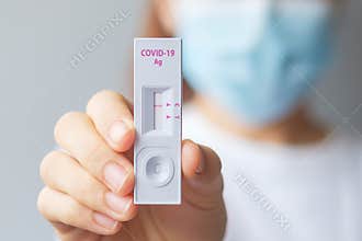 Woman holding Rapid Antigen Test kit with Negative result during swab COVID-19 testing. Coronavirus Self nasal or Home test,