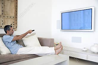 Man Using TV Remote In Living Room