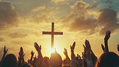Hands are raised in worship in front of a cross at sunset