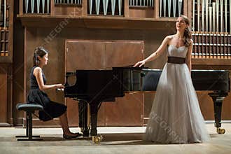 Woman pianist plays the piano and beautiful singer