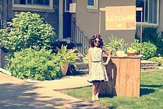 Retro girl wearing sunglasses with lemonade stand