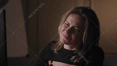 In a cozy indoor environment, a cheerful woman creates a warm and inviting atmosphere