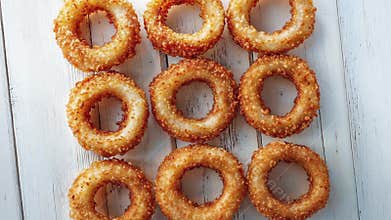 Crispy Onion Rings Neatly Arranged on White Wooden Table