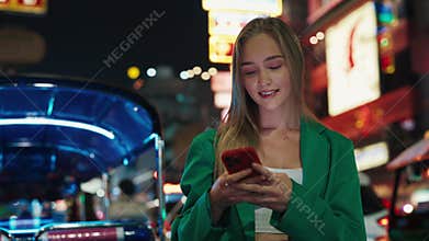 Portrait of happy female typing message on mobile phone