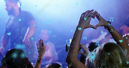 Diverse group of young people are dancing at concert, surrounded by digital icons