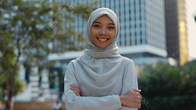 Attractive Young Muslim Woman Standing Outside with the Crossed Hands, Looking at Camera.