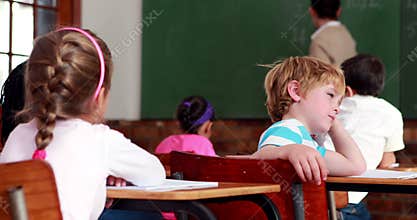Little bored boy turning to the camera during class