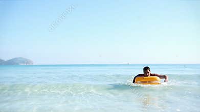 Young man on pool raft
