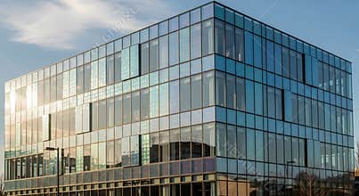 Modern office building with reflective glass facade and blue sky