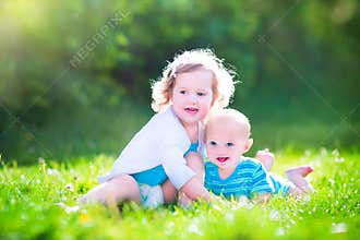 Baby brother and toddler sister in a garden