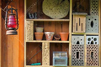 Shelf with insect hotel and garden utensils