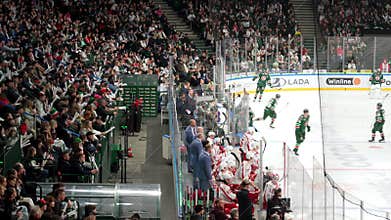 Backup players stand with sticks between roaring stands