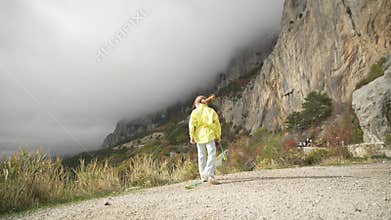 Athletic Woman Jumps and Dances with Juggling Clubs in Dramatic Foggy Mountains.