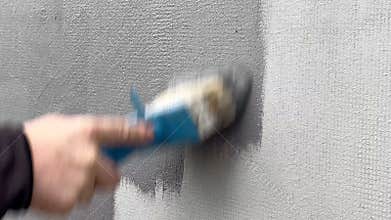 A person is mixing different shades of paint to create a unique color. The activity takes place in a home during the afternoon