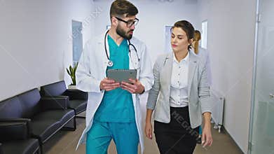 Good looking woman patient in the hospital have a conversation with the doctor after the health checkup they walking