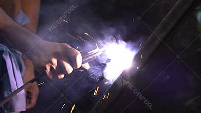 Steel welders with electric welding. No self-defense, unprotected with gloves. Slow motion.