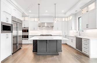 Modern white and grey kitchen with stainless steel appliances.
