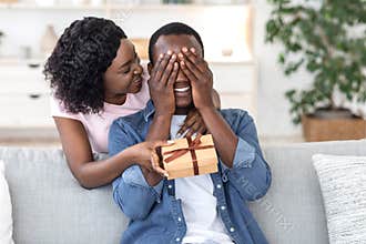 Black woman giving her boyfriend birthday gift