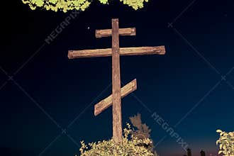 Huge wooden Orthodox eight-pointed cross against the sky after sunset on Mount Athos