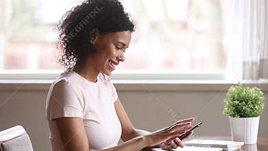 Smiling african american woman using smartphone dating app swiping